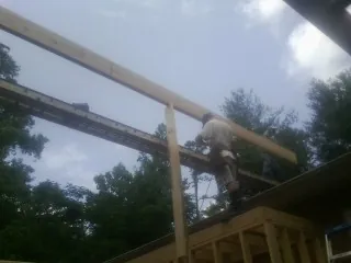 Carpenter setting a ridge beam over a new addition frame — Ice Dam Removal by Roofing Brothers in Umatilla