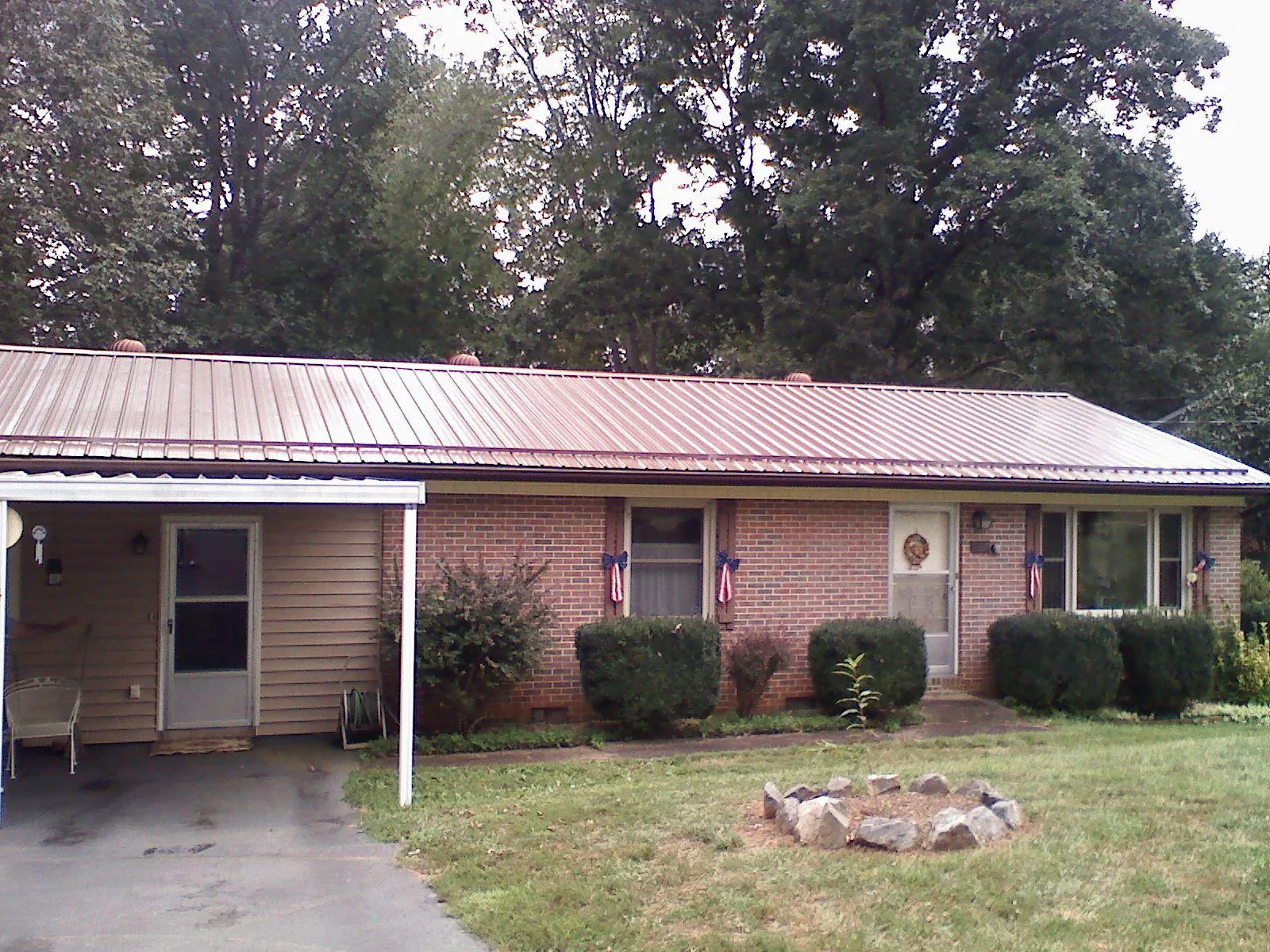 Bronze metal roof and carport on a brick ranch home — Roof Repair work by our crew in Umatilla